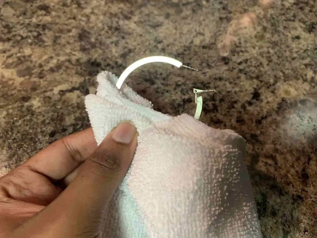 cleaning an earring with a cloth