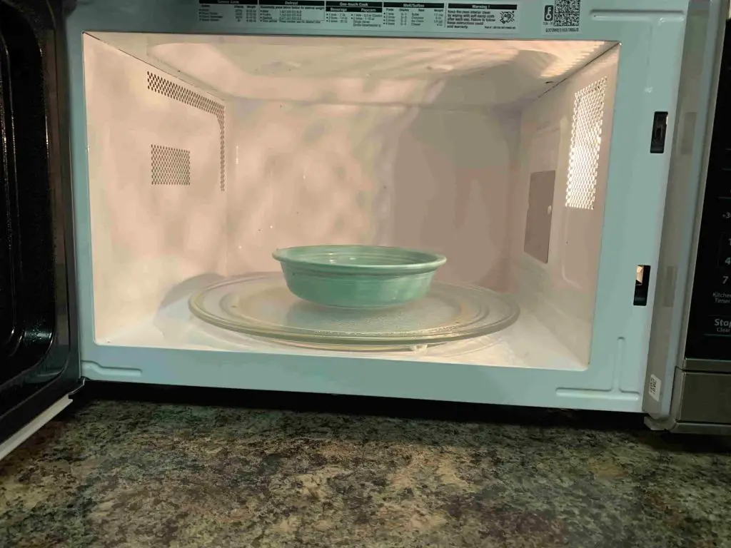 dish with lemons being placed inside of a microwave
