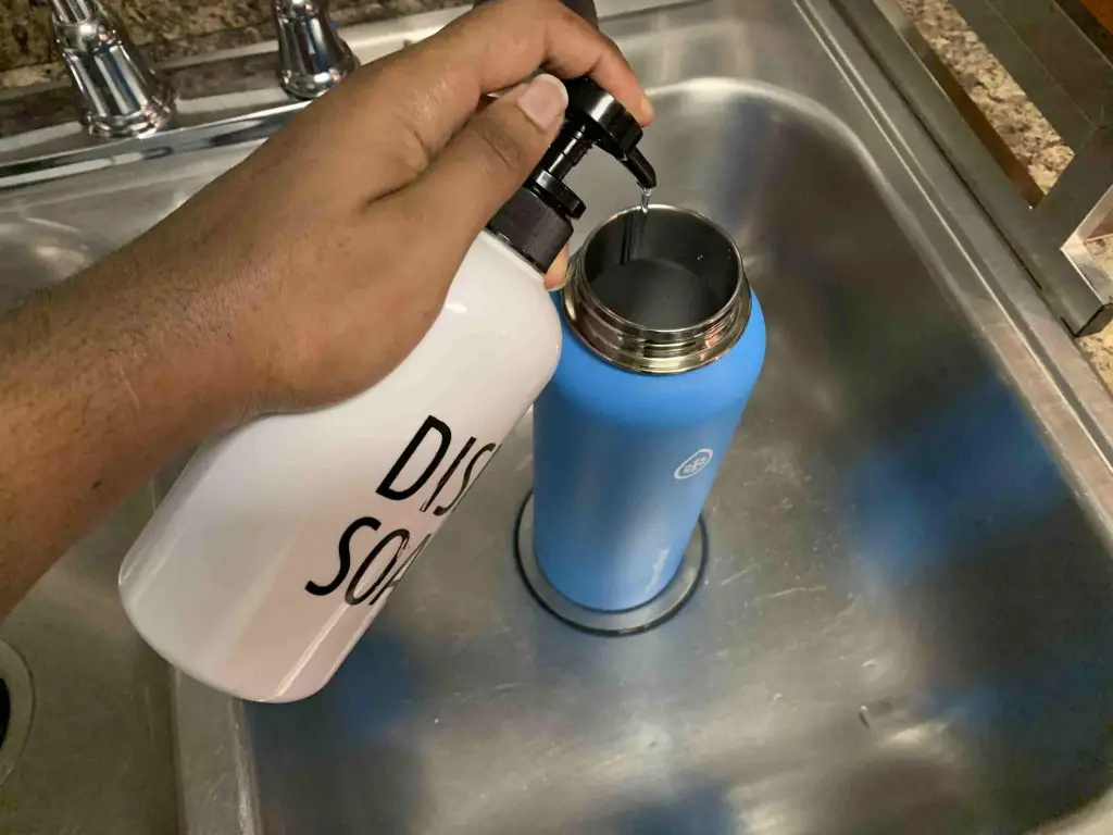 squeezing dishsoap inside of a thermoflask