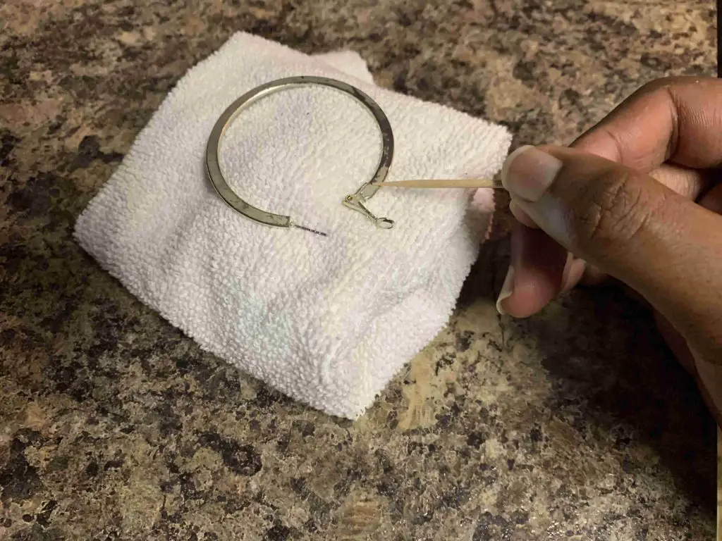 using a toothpick to clean an earring