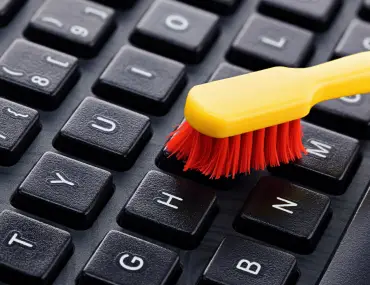 cleaning a keyboard with a toothbrush