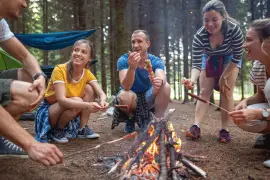 people eating around a camp fire