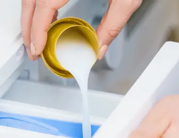 pouring fabric softener inside the washing machine
